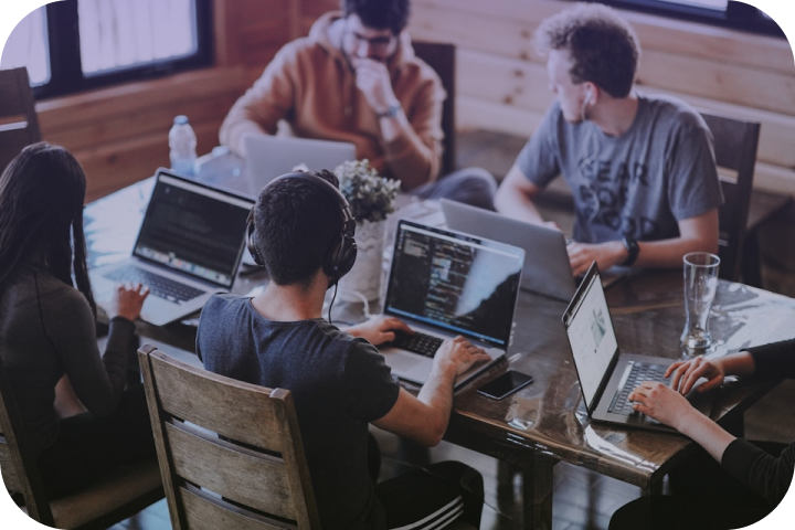 Community members collaborating around laptops